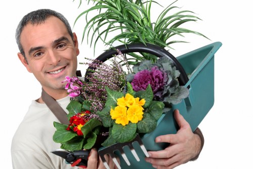 Worker using correct manual handling technique with garden materials